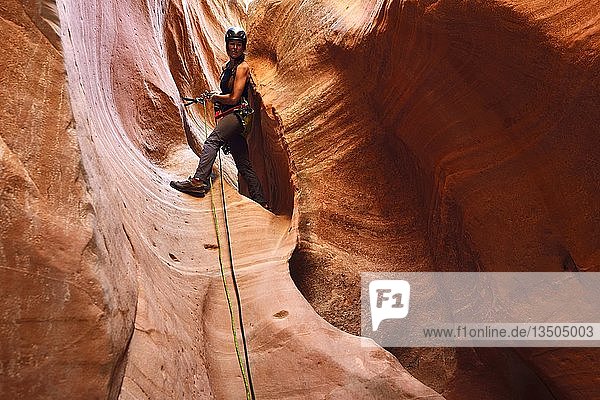 Frau beim Klettern im Huntress Slot Canyon außerhalb des Zion National Park  Utah  USA  Nordamerika