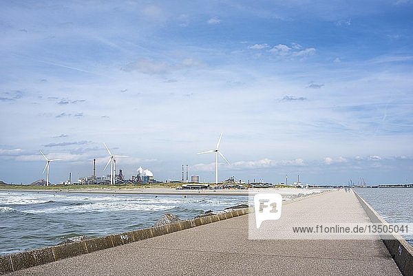 Damm an der Nordseeküste bei Wijk aan Zee  im Hintergrund Windmühlen und das Stahlwerk Tata  Ijmuiden  Nordholland  Niederlande