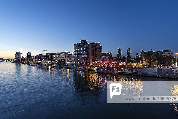 Evening view of the Spree river  on the right a colourfully illuminated restaurant  Kreuzberg  Berlin  Germany  Europe