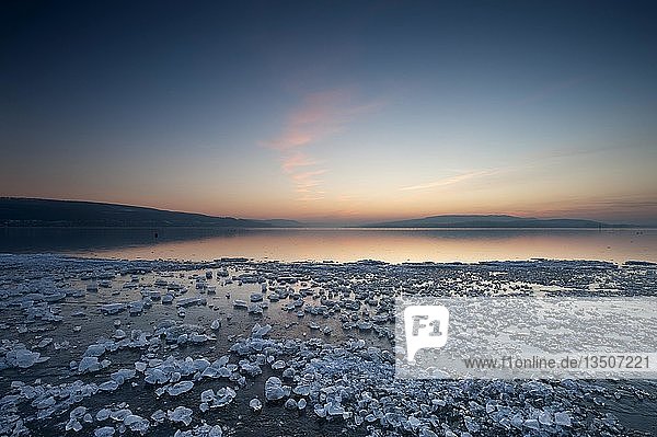 Eisbrocken auf vereister Oberfläche am Ufer der Insel Reichenau nach Sonnenuntergang  Baden-Württemberg  Deutschland  Europa