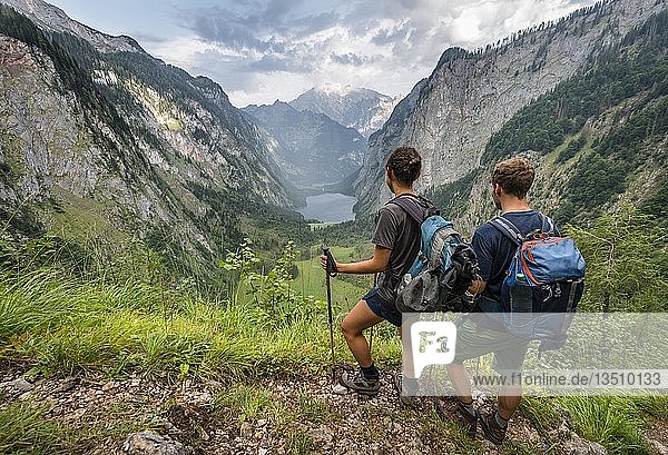 View of Obersee and KÃ¶nigssee  two hikers on the RÃ¶thsteig  behind Watzmann  Berchtesgaden  Upper Bavaria  Bavaria  Germany  Europe
