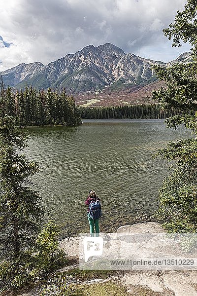 Weiblicher Wanderer steht am Seeufer  Pyramid Lake  hintere Berge  Pyramid Mountain  Jasper National Park National Park  Canadian Rocky Mountains  Alberta  Kanada  Nordamerika