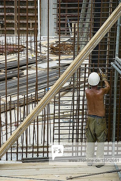 Bauarbeiter mit nacktem Oberkörper beim Verbinden von Stahlmatten  Vorbereitung für das Gießen von Zement  Deutschland  Europa