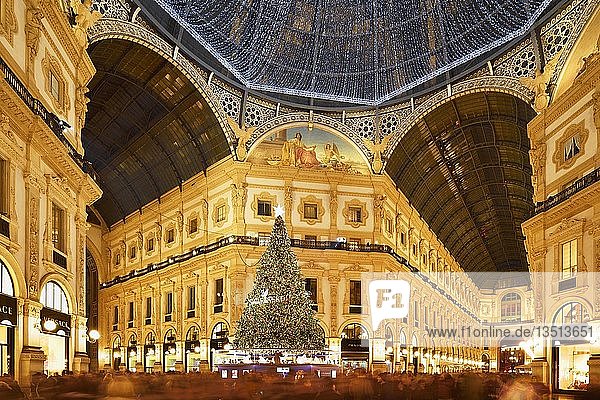 People marvel at Christmas tree and Christmas lights in luxury shopping arcade  covered gallery Galleria Vittorio Emanuele II  Blue Hour  Milan  Lombardy  Italy  Europe