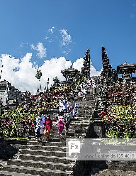 Balinesische Gläubige in traditioneller Kleidung gehen die Treppe hinunter  geteiltes Tor  Candi bentar  Muttertempel Besakih  Bali Hinduismus  Pura Penetaran Agung Besakih  Banjar Besakih  Bali  Indonesien  Asien