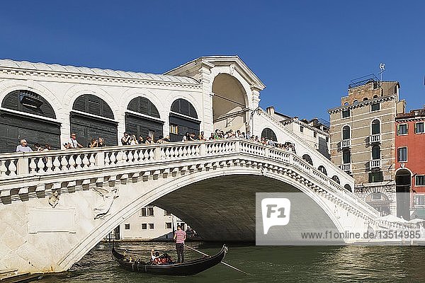 Touristen auf der Rialto-Brücke über den Canal Grande mit traditioneller Gondel  San Polo  Venedig  Venetto  Italien  Europa