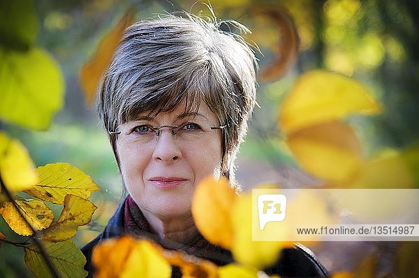 Porträt einer Frau mit Herbstblättern