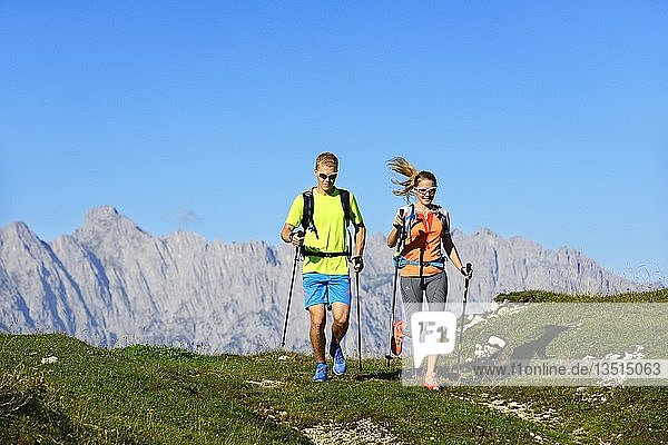 Trail running  hikers on the Eggenalm  behind Wilder Kaiser mountain range  Reit im Winkl  Upper Bavaria  Bavaria  Germany  Europe