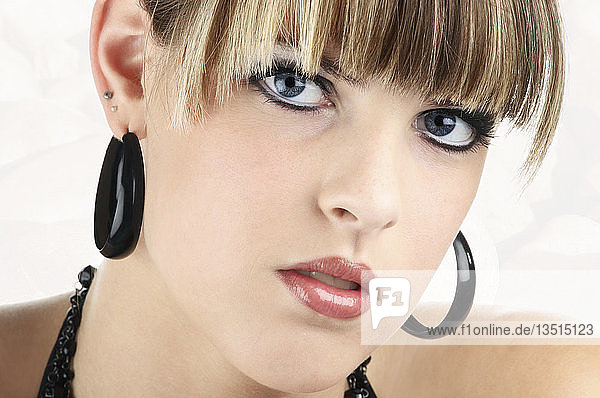 Porträt einer jungen Frau mit schwarzen Ohrringen