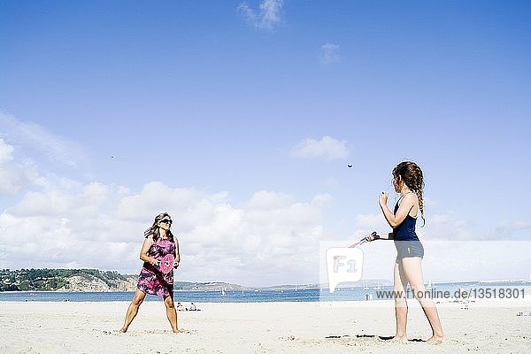 Mutter und Tochter spielen am Strand Schläger und Ball  Morgat  Bretagne  Frankreich  Europa