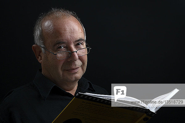 Porträt eines älteren Mannes mit Buch
