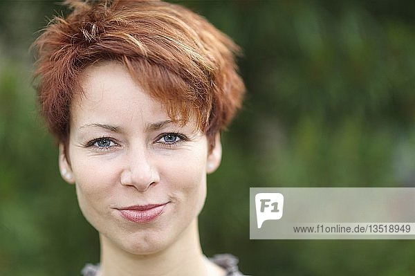 Smiling young woman with short red hair  portrait