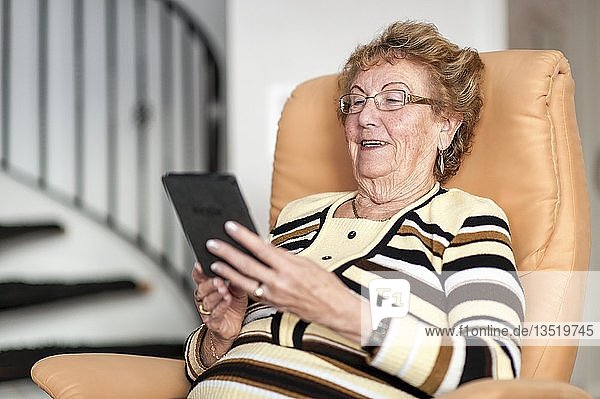 Lächelnde ältere Frau  die ein eBook liest  Deutschland  Europa