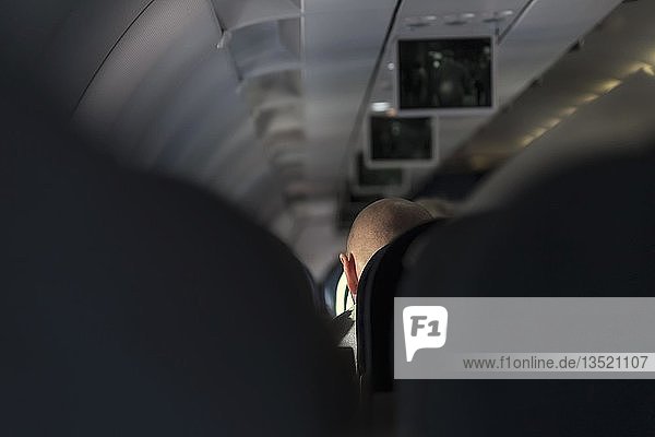 Hinterkopf eines Mannes in einem Flugzeug