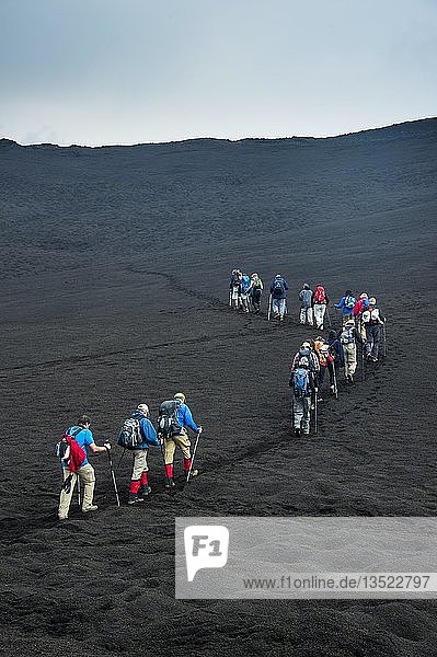 Tourists walking in a line through the lava sands of the Tolbachik volcano  Kamchatka  Russia  Europe
