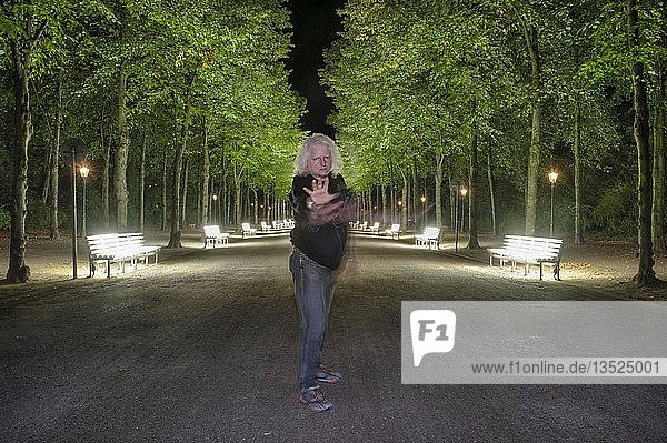 Mann in Verteidigungsstellung vor den Reihen von unaufgeräumten Bänken im Hofgarten  Düsseldorf  Nordrhein-Westfalen  Deutschland  Europa