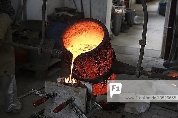 Arbeiten in einer Gießerei flüssige Bronze wird in Form gegossen Deutschland Europa