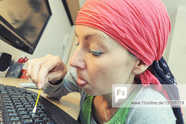 Putzfrau reinigt eine Computertastatur mit einem Wattestäbchen  Deutschland  Europa