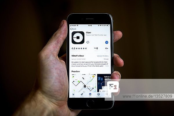 Hand  die ein iPhone hält  auf dem die Uber-App  eine Taxi- und Mitfahr-App  im Apple App Store angezeigt wird  App-Symbol  Display  iPhone  iOS  Smartphone  Deutschland  Europa