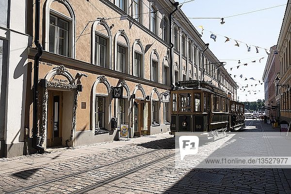 Straßenbahn fährt durch eine Häuserreihe  Helsinki  Finnland  Europa
