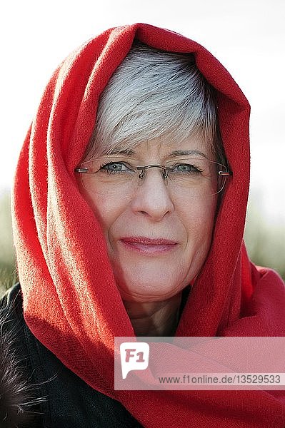Portrait einer Frau mit rotem Schal um den Kopf
