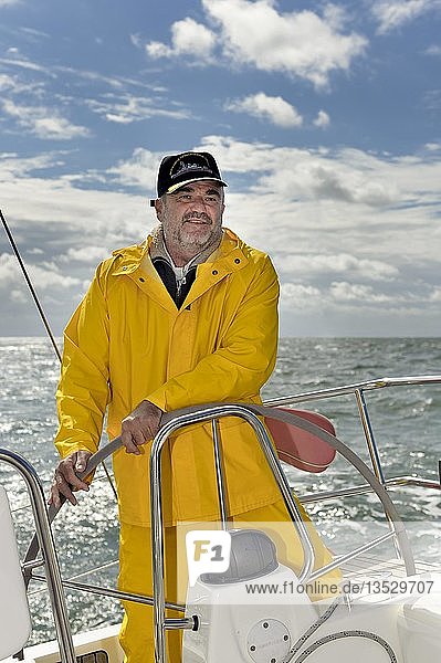 Der Skipper steht am Steuer seiner Yacht