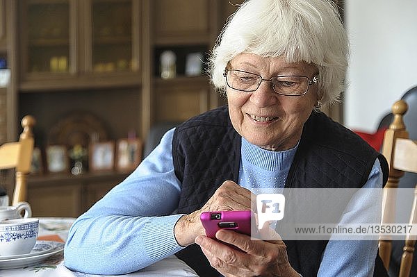 Seniorin mit einem pinkfarbenen Smartphone Grevenbroich Nordrhein-Westfalen Deutschland Europa