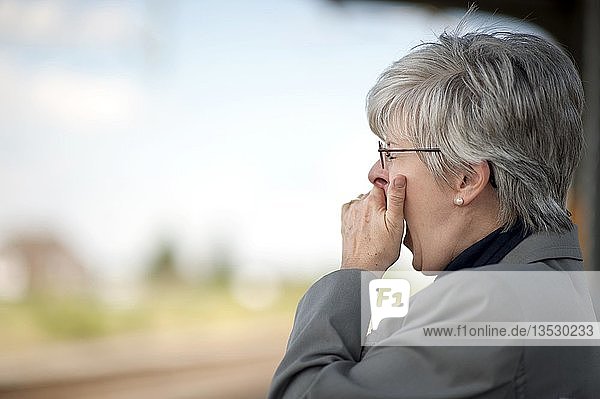 Woman  50 +  yawning and holding her hand over her mouth
