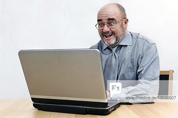 Ein älterer Bürger  der begeistert im Internet surft