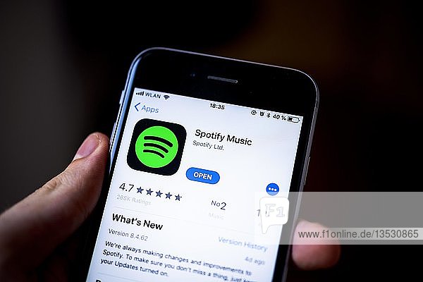 Hand hält iPhone  Spotify Music App im Apple App Store  Musik-Streaming-Dienst  App-Symbol  iPhone  iOS  Smartphone  Display  Deutschland  Europa