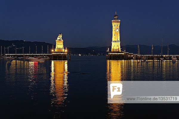 Beleuchteter bayerischer Löwe und der Leuchtturm in der Abenddämmerung  Lindau am Bodensee  Schwaben  Bayern  Deutschland  Europa