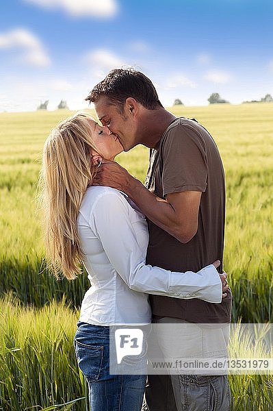 Couple kissing on the edge of a corn field