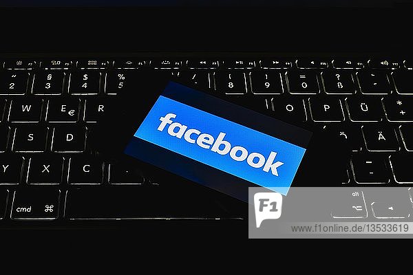 Smartphone mit Logo Facebook auf Tastatur Symbolbild Cybercrime Computerkriminalität Datenschutz Deutschland Europa