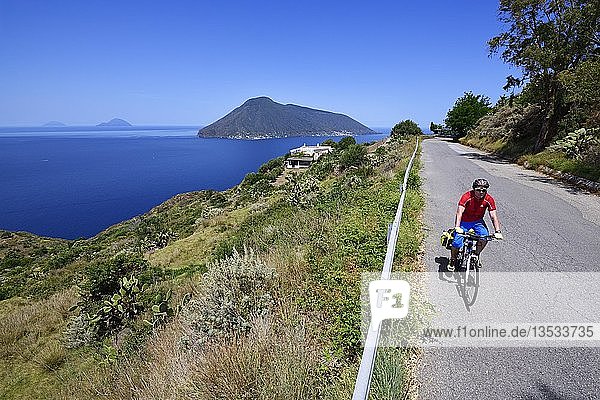 Cyclist at Punta del Legno Nero at Quattropani overlooking the island of Salina  Lipari  Aeolian Islands or Aeolian Islands  Sicily  Italy  Europe