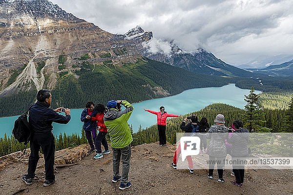 Asian tourists pose for a photo  turquoise lake  Peyto Lake  Rocky Mountains  Banff National Park  Alberta Province  Canada  North America