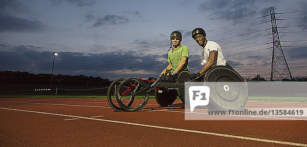 Porträt selbstbewusster  querschnittsgelähmter Sportler auf einer Sportbahn  der nachts für ein Rollstuhlrennen trainiert