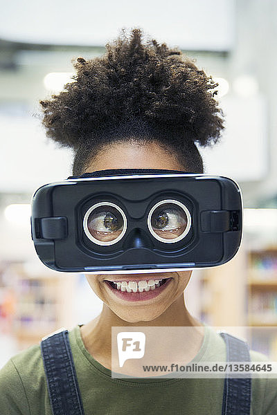 Porträt einer dummen  schielenden Junior-High-Schülerin  die einen Virtual-Reality-Simulator trägt