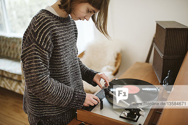 Mädchen spielt Schallplatte im Wohnzimmer
