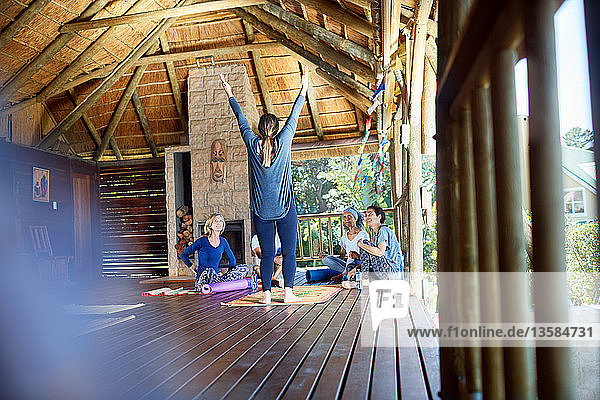 Frau leitet Yoga-Retreat in Hütte