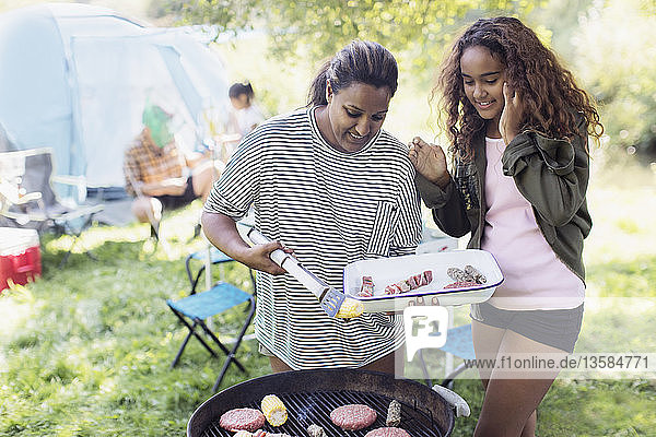 Mother and daughter barbecuing at campsite