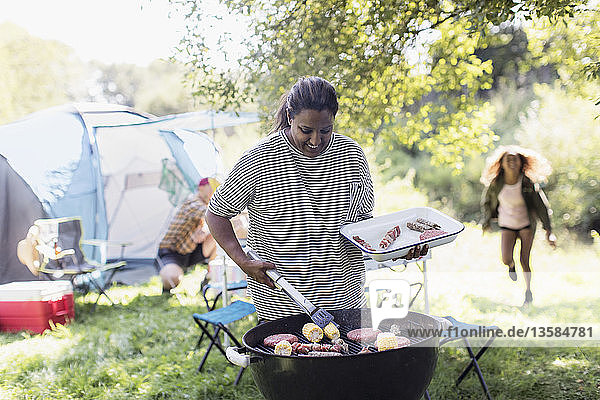 Frau beim Grillen auf dem Campingplatz