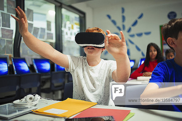 Neugieriger Schüler der Junior High School benutzt einen Virtual-Reality-Simulator im Klassenzimmer