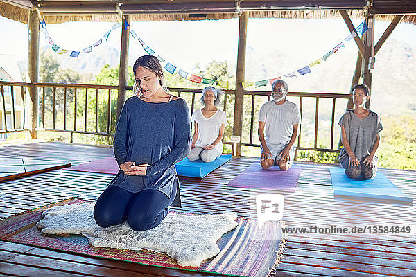 Menschen meditieren während eines Yoga-Retreats in einer Hütte