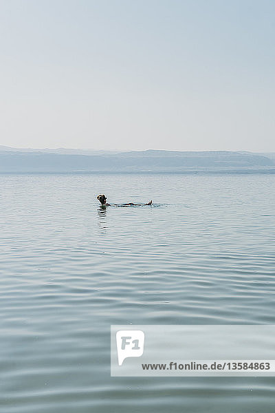 Man floating  swimming in Dead Sea  Jordan