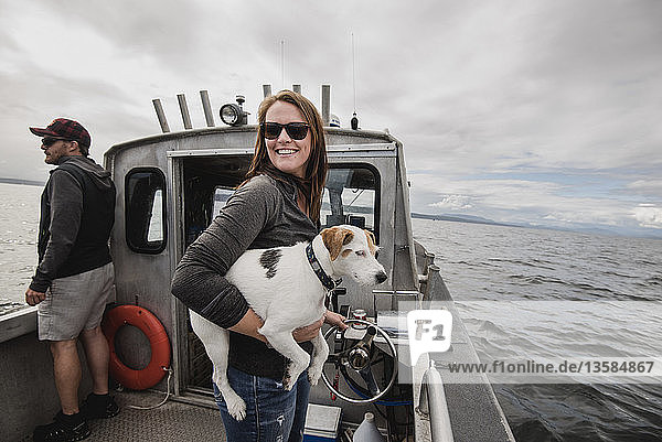 Portrait smiling woman with dog on fishing boat