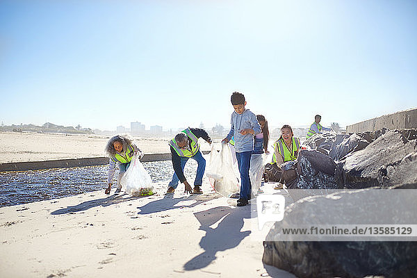 Freiwillige beseitigen Müll am sonnigen Strand
