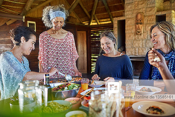 Friends enjoying healthy meal in hut during yoga retreat