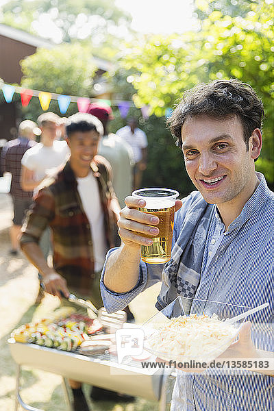 Porträt glücklicher Mann beim Biertrinken und Grillen im Hinterhof