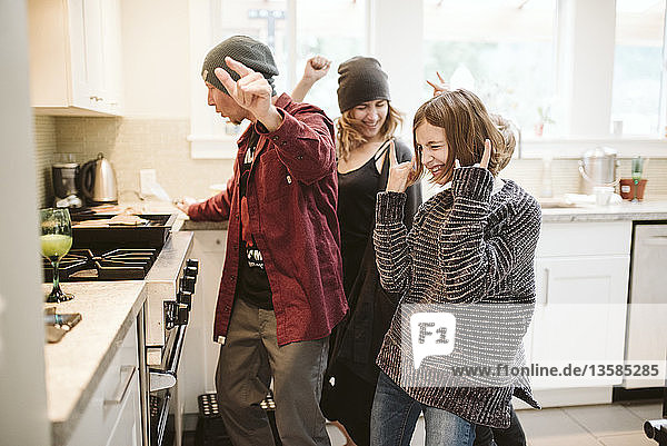 Carefree family dancing and cooking in kitchen