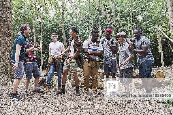 Mens group talking  hiking in woods